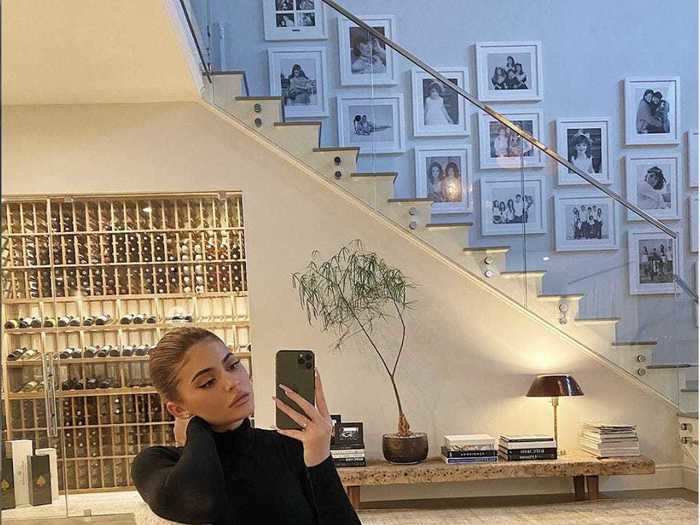 Kylie Jenner lounged in her home foyer, which features neutral decor.