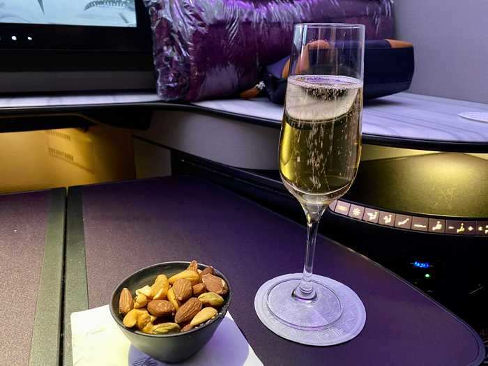 A few minutes after that, a different flight attendant brought my first drink — champagne — and a dish of mixed nuts.