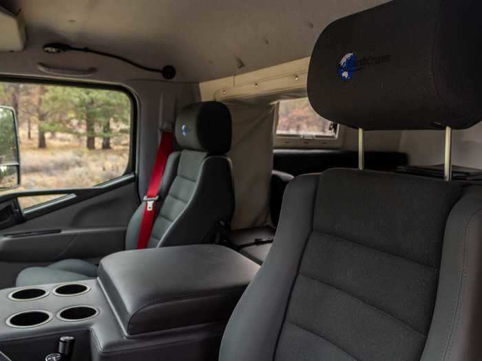 The center console between the driver and front passenger seat includes storage, padded armrests, two USB outlets, a 12-volt socket, and four cup holders.