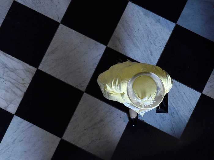 An aerial photo of Queen Elizabeth walking diagonally on a checkered floor is reminiscent of how the queen game piece moves in chess.