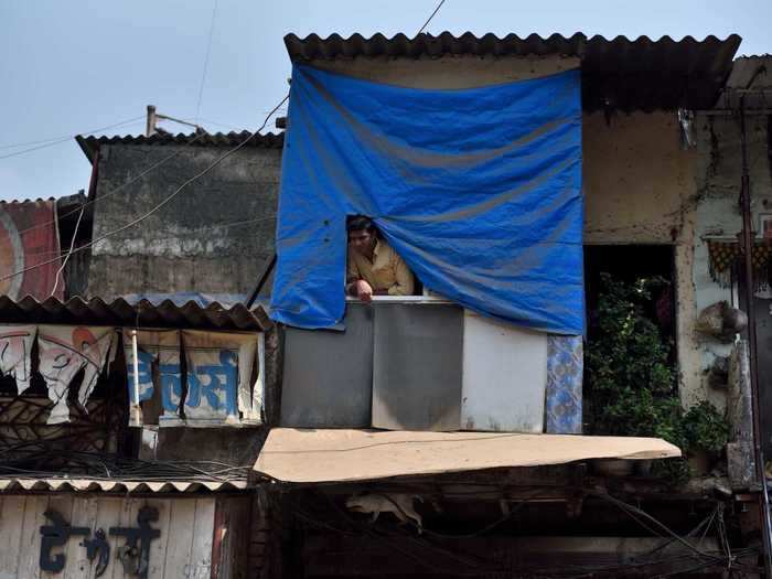 A man peers over the streets of Mumbai from his home on April 17, after India imposed a 21-day lockdown at the end of March.