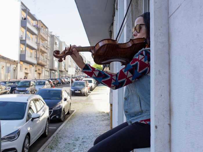 Many musicians have taken to their windows to perform. A violinist in Lisbon, Portugal, played music from her window to cheer up her neighbors who are confined to their homes.