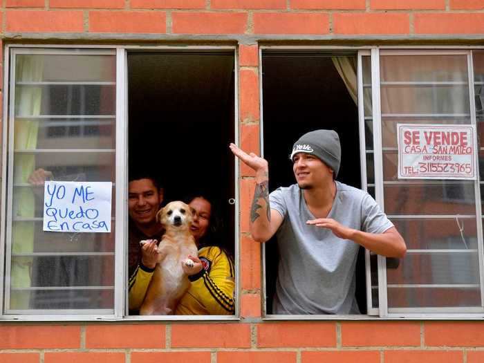 In Bogota, Colombia, people are seen dancing from their windows as police officers drive through neighborhoods as way to cheer people up during lockdowns.