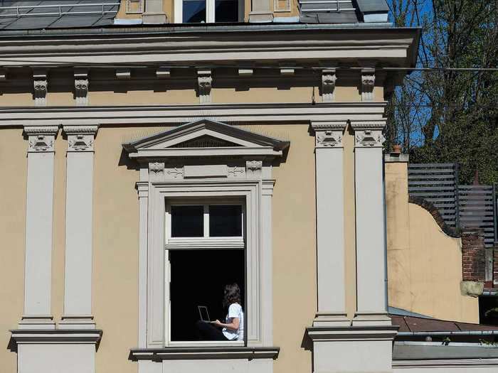 The lockdowns have also forced many people to work from home.  A woman in Krawkow, Poland is photographed working from her laptop from her apartment window.