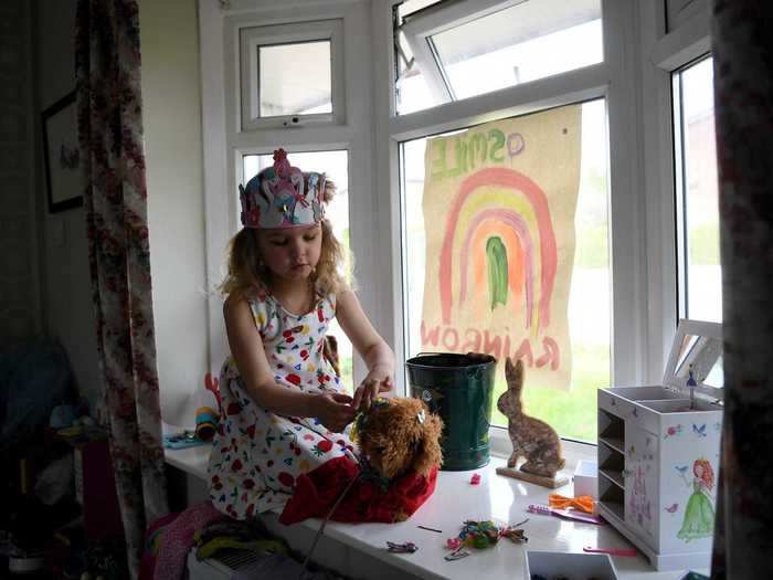 In the UK, a father photographed his daughter playing with toys in front of their window.