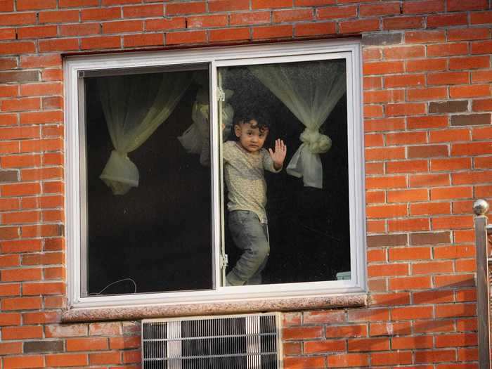 A child in Queens, New York, presses his hand against the window as New Yorkers remain under lockdown until at least May 15.