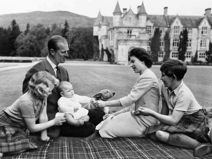 1960: Even the royals need family time. This family photo shows the Duke of Edinburgh and his wife, the Queen, entertaining the kids, including a baby Prince Andrew, as they relax in the grounds of Balmoral Castle.