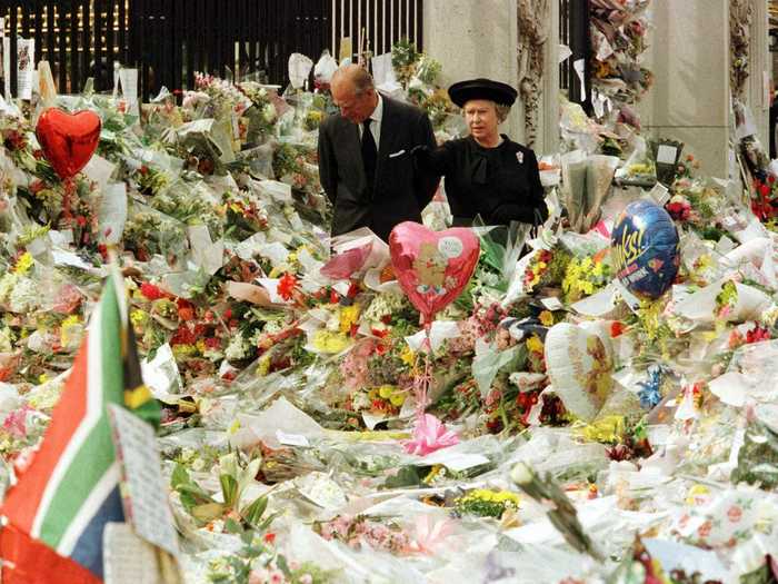 1997: Tragedy struck a year later also when Princess Diana was killed by injuries sustained in a car crash in Paris. This photo shows the Queen and Prince Philip observing the vast sea of flowers left outside Buckingham Palace after Diana