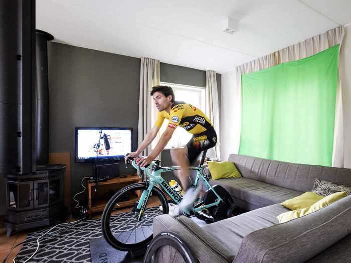 In the Netherlands, cyclist Tom Dumoilin dressed the part to ride in a virtual race from the living room of a holiday home on April 19.