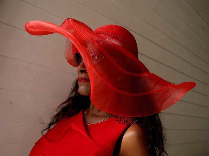 This voluminous red hat gracefully draped over a woman