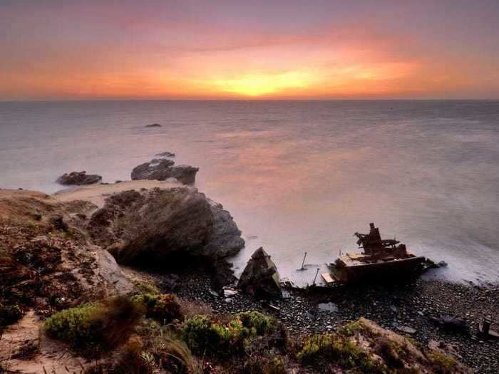 The beached wreck of an unknown tugboat is in Vila Nova de Milfontes, a picturesque seaside village in Odemira, Portugal.