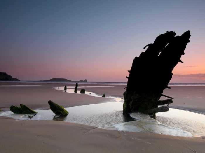 The ethereal remains of the Helvetia, a 19th-century Norwegian ship, are scattered over three miles of sand in Rhossili Bay, a beach in Swansea, Wales.