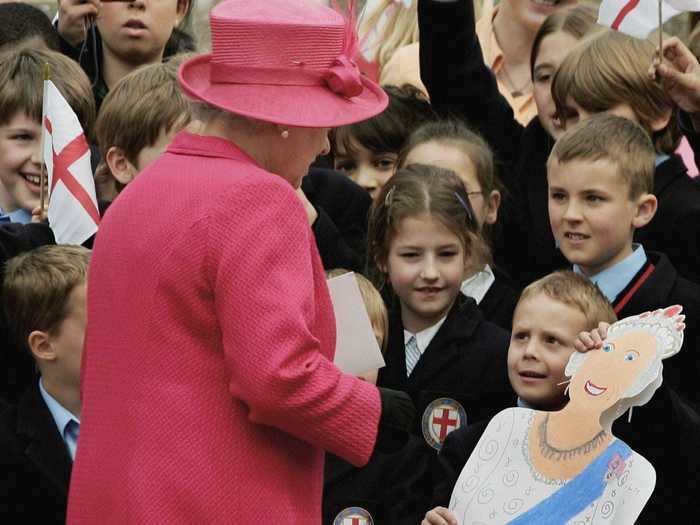 A young royal fan holding a cardboard cutout of the queen looked confused upon meeting the real Queen Elizabeth.