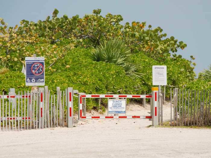 Entrances to the beach are closed off by metal gates ...