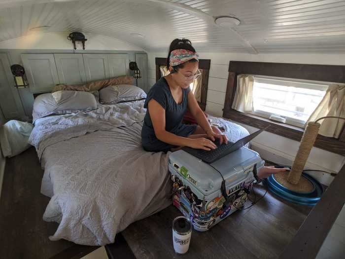 Sam typically works remotely on her computer in the master loft overlooking the home. She uses a cooler as a makeshift desk.