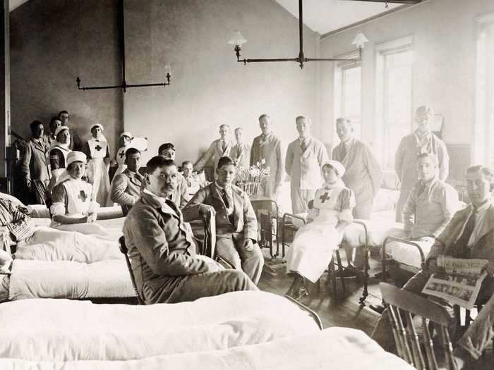 In hospital wards, Red Cross nurses dressed soldiers