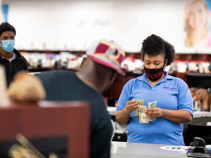 A worker at Shoe Dept. rings up a customer at Columbia Place Mall on April 24, 2020, in Columbia, South Carolina.