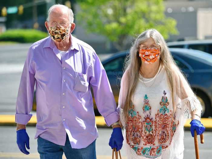 A couple walks through the parking lot of the Anderson Mall in Anderson, South Carolina on the first day it reopened on Friday.