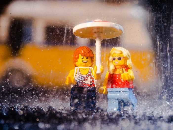 The weather suddenly took a turn for the worse at the beach and the newlyweds posed for a snap in the rain under an umbrella.