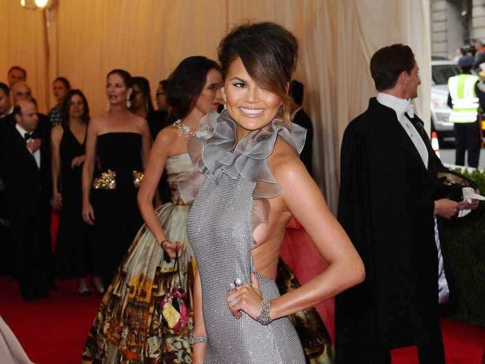 In 2014, Chrissy Teigen arrived wearing a backless gown with a ruffled neckline.