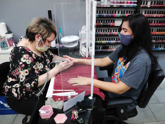 Elsewhere in Dallas, some salons have already been up and running, like this one that erected plastic barriers between the aesthetician and the customer ...