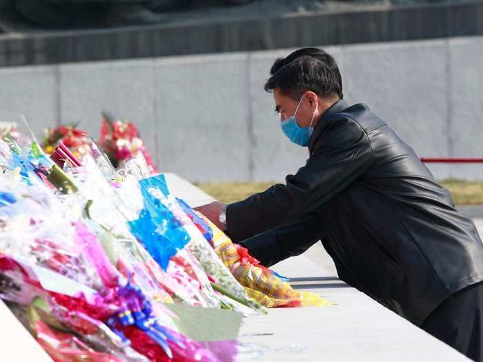 Citizens donned face masks to lay flowers near the statues of Kim Il Sung, and the former leader Kim Jong Il.