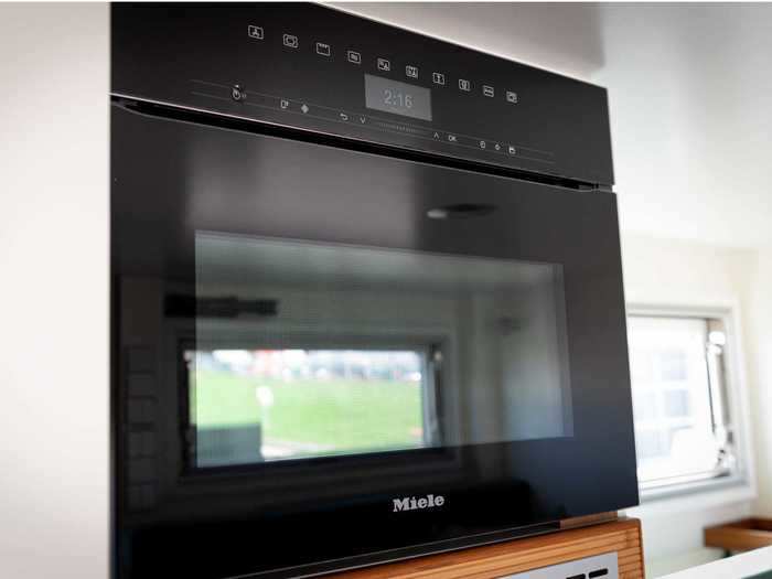 Kitchenware can be stored in the cabinets around the kitchen area.