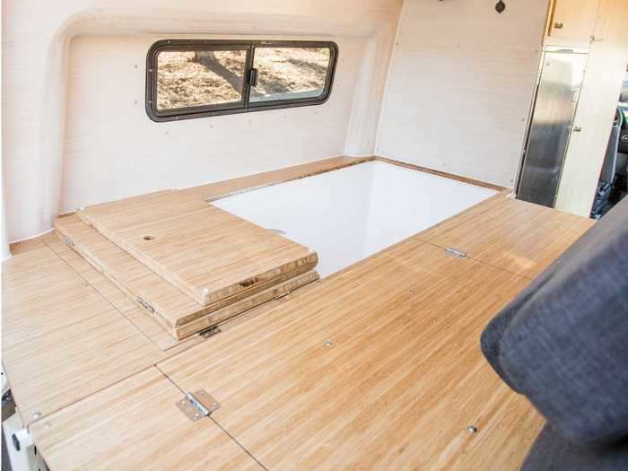 The wooden panels on one of the seating benches can be folded up to reveal the soaking tub, which is integrated directly into the bench.