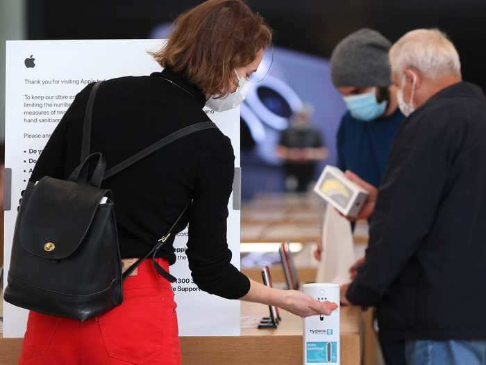 Customers apply hand sanitizer before browsing products and testing out electronics on display.