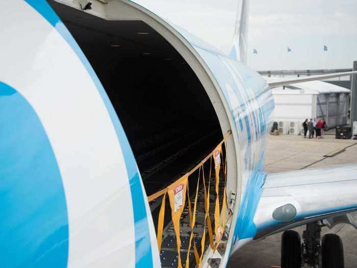 Freight is loaded through an oversized cargo door on the aircraft