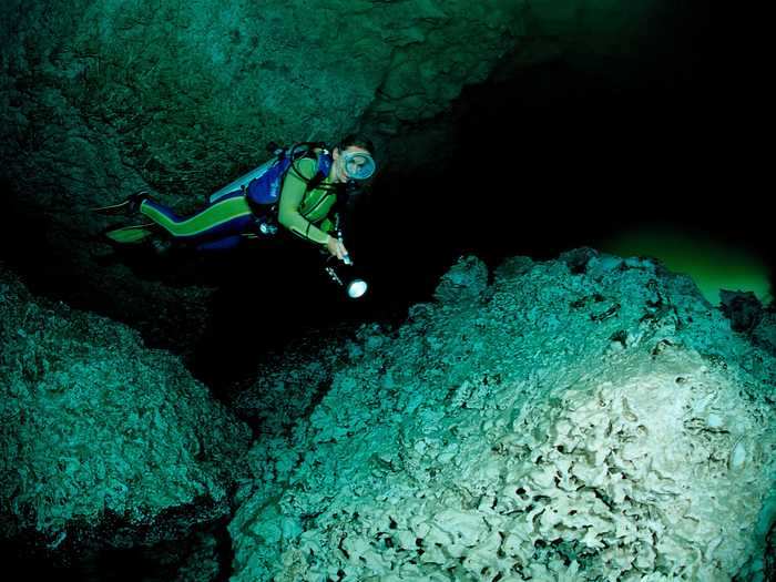 A scuba diver exploring an underwater cave in Laguna Pepe, Punta Cana, in the Dominican Republic.