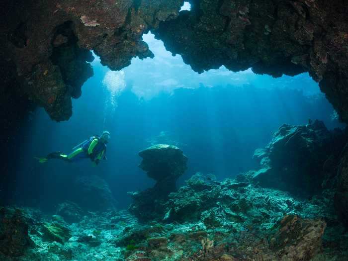 Another location for tropical underwater caves is Fiji. This scuba diver explored this one in Fiji