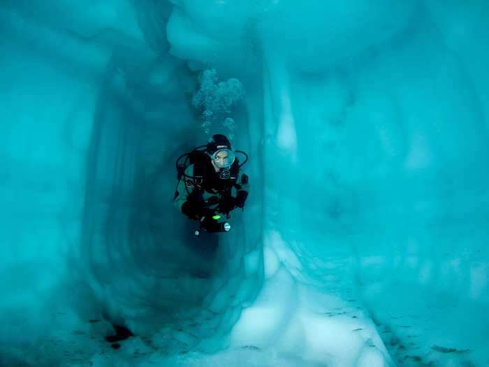 A scuba diver swims through an ice cave in Lake Sassolo in Sambuco Valley, Ticino, Switzerland.