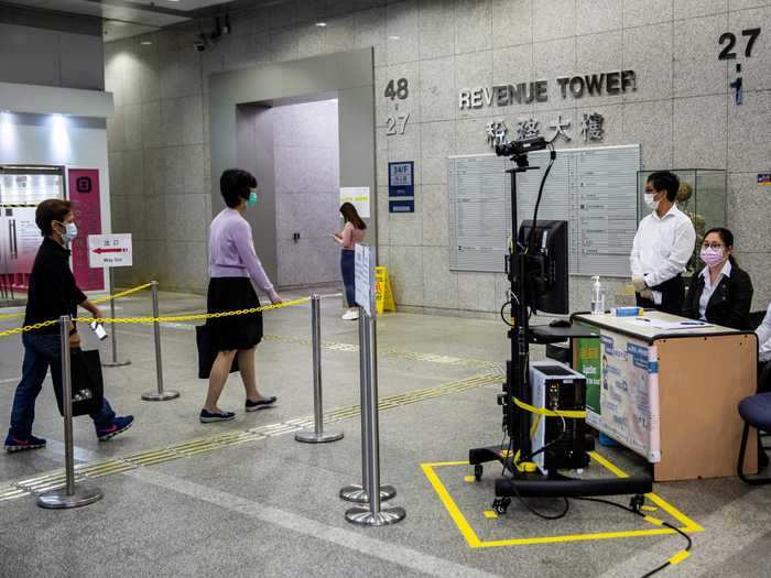 Temperature checks: In Hong Kong, temperature checks have been widespread since January. Here, government workers get their temperatures checked by security in the office building