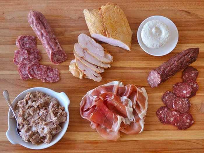 A charcuterie platter that includes duck, pork, and chicken