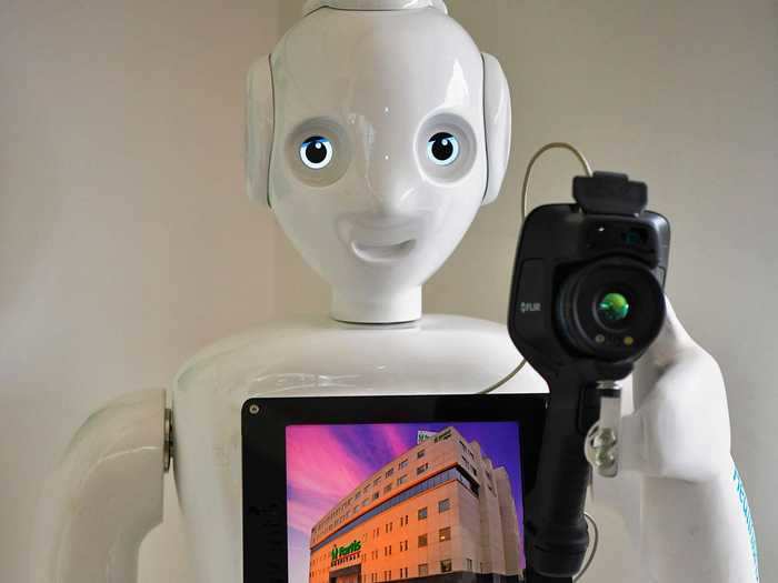 A thermal camera-equipped robot takes a patient