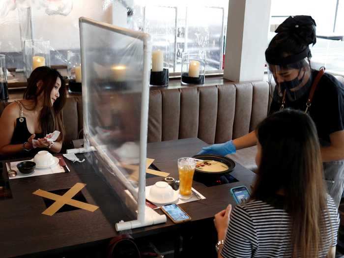 But in some places, a plastic divider is not enough. Diners in this Bangkok restaurant, for example, have been asked to sit diagonally from each other to maximize their distance.