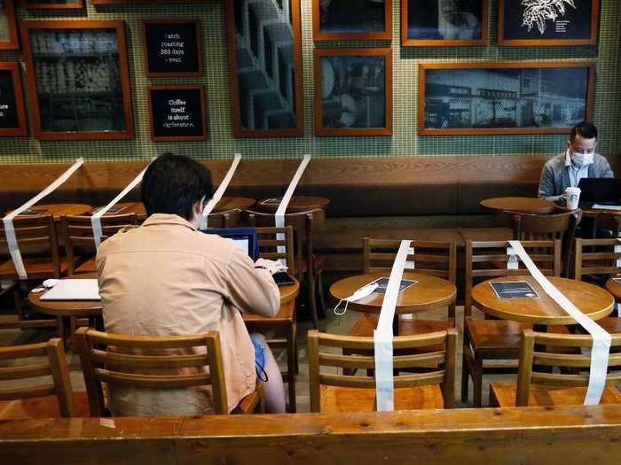 In other places, like this local Starbucks shop in Hong Kong, entire tables have been taped-off so that people can sit as far away from each other as possible.