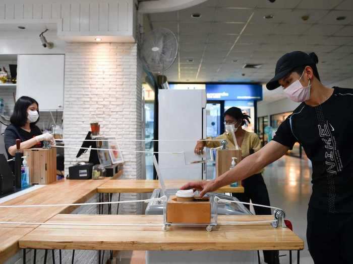 Coffee chains and fast-food restaurants are also having to make changes during the pandemic. This cafe in Bangkok is using a contactless pulley system to serve its customers.