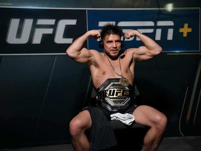 Henry Cejudo flexed his biceps for the camera with his freestyle wrestling Olympic gold medal from the 2008 games around his neck, and UFC world title belt strapped around his waist.