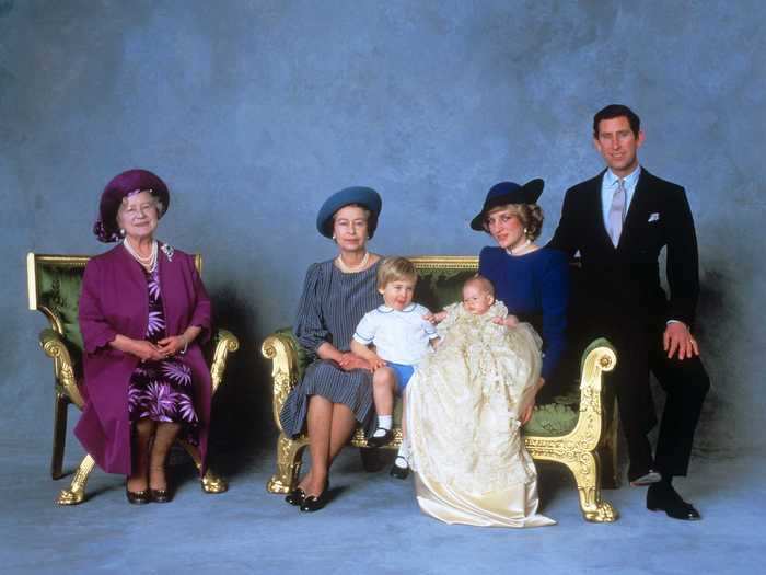 This adorable photo of the royal family before the ceremony shows a baby Prince Harry reaching out to touch his big brother.