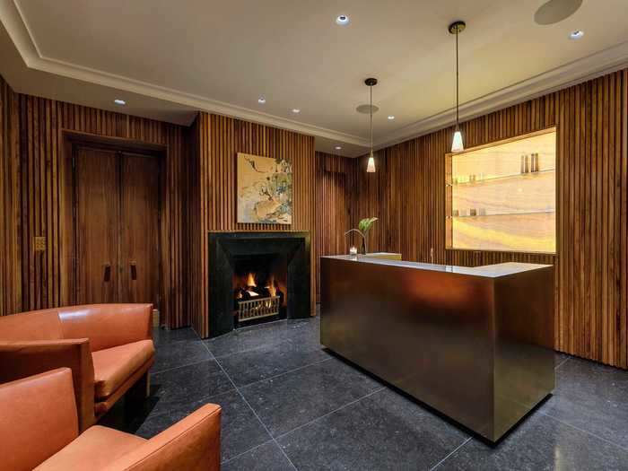 The wet bar features wood walls and a fireplace.