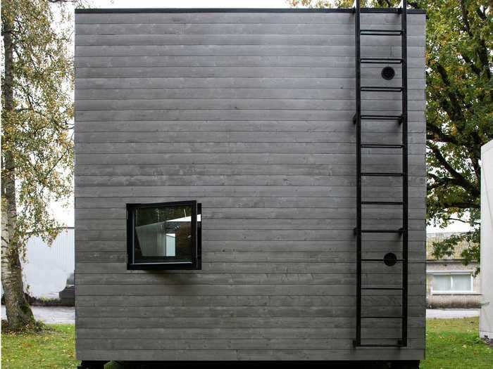 The exterior of the home includes a ladder that drains rainwater, an open mailbox, and a bicycle holder.