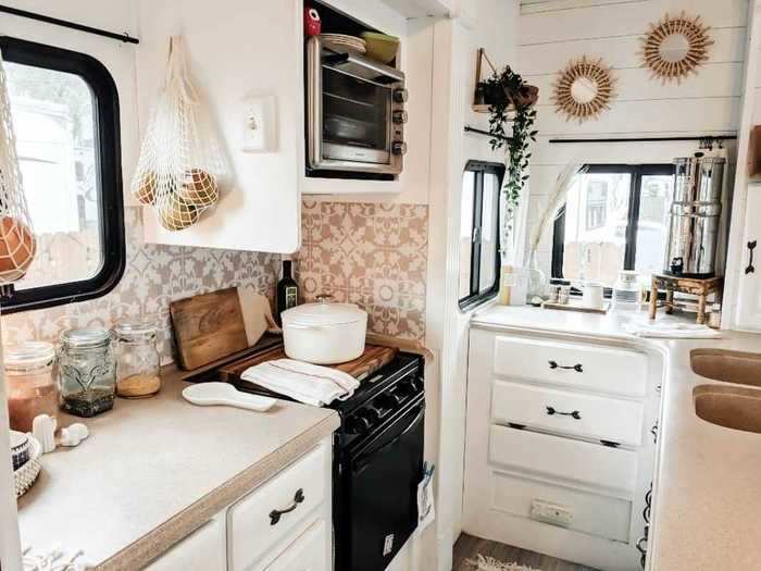 The kitchen has a stove, a toaster oven, and a two-basin sink built into an island.