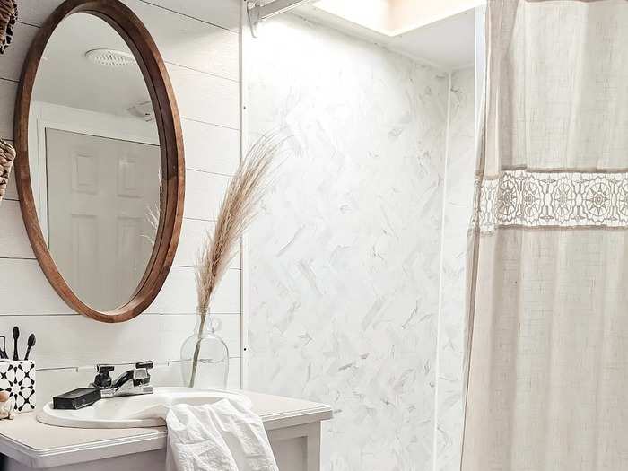 The white and muted color scheme continues into the bathroom.