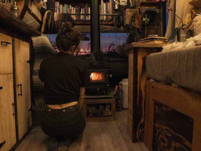 In addition to the essentials, they installed homey things like a tiny wood stove and a bookshelf.