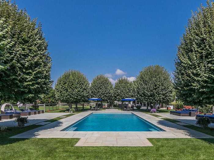 Lounge areas and trees surround the pool.