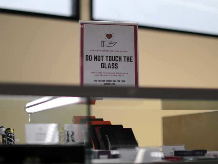 Signs remind those who do decide to visit the store in person not to touch the glass in an effort to prevent the spread of COVID-19.