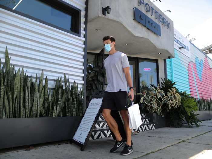 Delivery partner Alex Brown, 27, carries a bag for a customer at The Pottery Cannabis Dispensary.