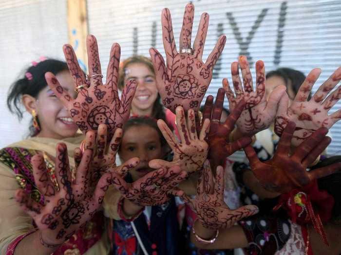 In Mosul, Iraq, displaced Iraqi girls who once fled their homes pose for a photograph as they celebrate the beginning of Eid.